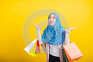 Asian Muslim Arab woman Islam wear hijab she holding colorful shopping bags so glad