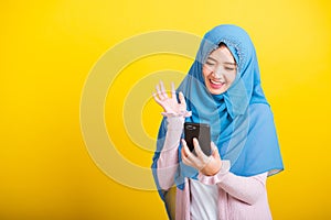 Asian Muslim Arab woman Islam wear hijab she video call mobile smart phone raise hand say hello