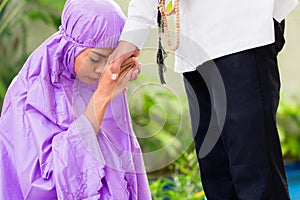 Asian Muslim couple, man and woman, praying at home