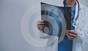 Asian Muslim doctor in hijab and scrubs headphones around her neck Stand confidently in the medical office, isolated on white