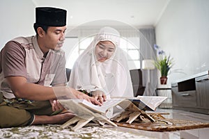 Asian Muslim family reading quran together at home