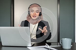 An Asian Muslim female call centre agent is providing a positive customer experience over the phone