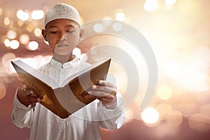 Asian muslim kid reading koran