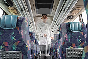 asian muslim man doing eid mubarak traveling back to his hometown by riding a bus