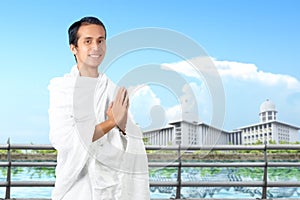 Asian Muslim man in ihram clothes standing and praying