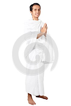 Asian Muslim man in ihram clothes standing and praying