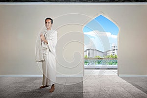 Asian Muslim man in ihram clothes standing and praying