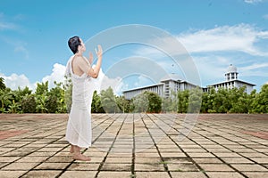 Asian Muslim man in ihram clothes standing and praying