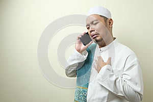 Asian Muslim man looks sad while receiving phone