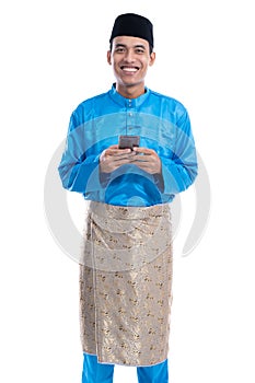 Asian muslim man with mobile phone wearing koko melayu