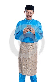 asian muslim man with mobile phone wearing koko melayu