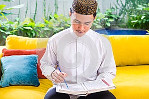 Asian Muslim man reading Koran