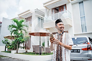 Asian Muslim man with songkok using smartphone photo