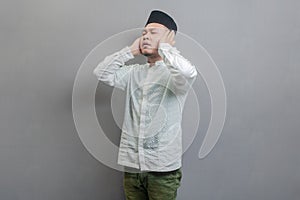 Asian Muslim man standing reciting the call to prayer