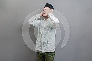 Asian Muslim man standing reciting the call to prayer