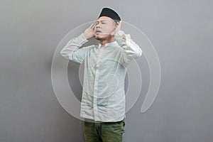 Asian Muslim man standing reciting the call to prayer