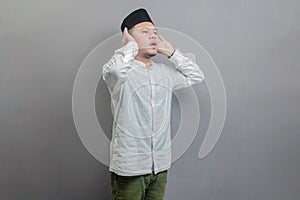 Asian Muslim man standing reciting the call to prayer