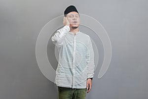 Asian Muslim man standing reciting the call to prayer