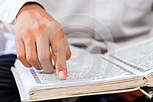 Asian Muslim man studying Koran or Quran