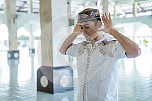 asian muslim man takbir solat at the mosque