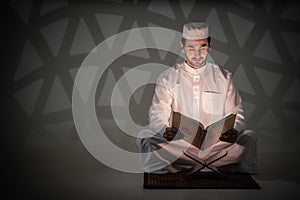 Asian muslim prayer sitting in mosque and read holy al quran book