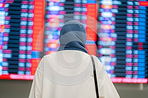 An Asian Muslim wearing a blue hijab is preparing for a vacation and she is at the airport.