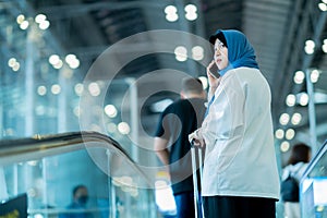 An Asian Muslim wearing a blue hijab is preparing for a vacation and she is at the airport