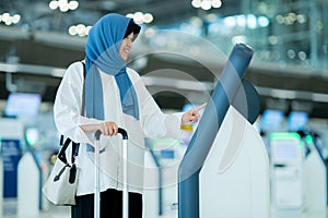 An Asian Muslim wearing a blue hijab is preparing for a vacation and she is at the international airport.