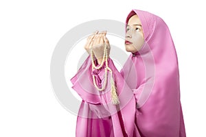 Asian Muslim woman in veil praying with prayer beads on her hands