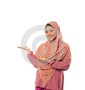 Asian Muslim woman wearing hijab with hands presenting something