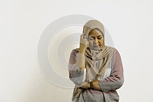 Asian Muslim woman wearing hijab or headscarf thinking while look downward