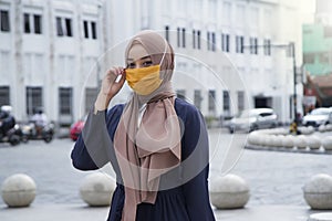 asian muslim woman wearing hijab or jilbab and fabric mask at malioboro area, Yogyakarta. covid-19 virus pandemic new normal