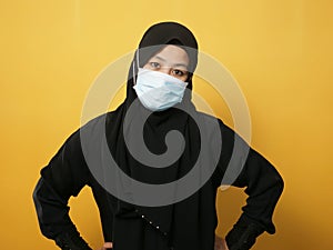 Asian muslim woman wearing hijab and mask during coronavirus covid pandemic new normal, woman wearing face protective mask,