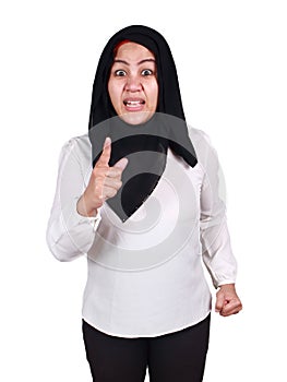 Asian muslim woman wearing hijab pointing to camera with angry expression, giving warn