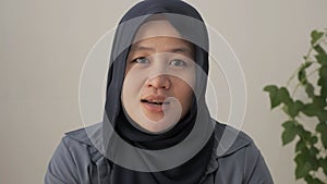 Asian muslim woman wearing hijab talking to camera, POV of islamic arabic lady talk to webcam make video conference call job