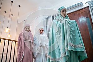 Asian Muslim women in Muslim clothing perform takbir movements