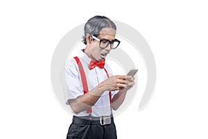 Asian nerd with an ugly face holding mobile phone with shocked expression