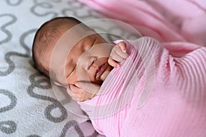 Asian newborn baby sleeping in pink cloth