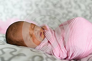 Asian newborn baby sleeping in pink cloth