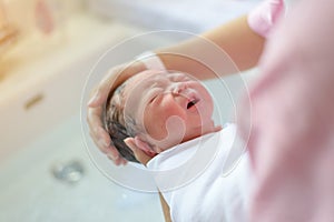 Asian newborn bathing by his mother