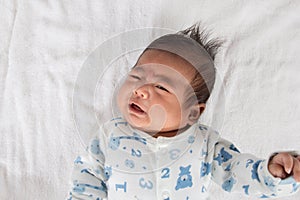 Asian newborn crying on white towel