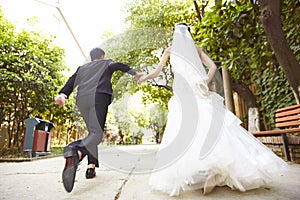 Asian newly-wed running on street