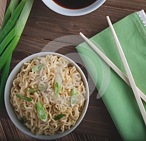 Asian noodles in bowl with chopsticks and green onions