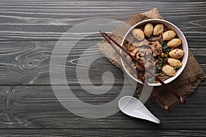 Asian noodles with pork, pork balls, chopsticks and vegetables on dark background. Close up Thai boat noodle culture style top vie
