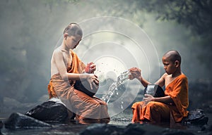 Asian Novice monks cleaning alms bowl