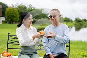 Asian nurse caring for an old man in the garden at home, nurse caregiver supporting health insurance at home