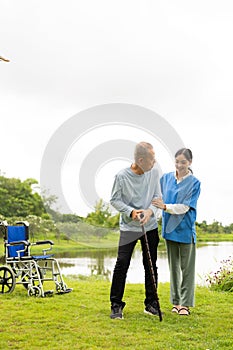 Asian nurse caring for an old man in the garden at home, nurse caregiver supporting health insurance at home