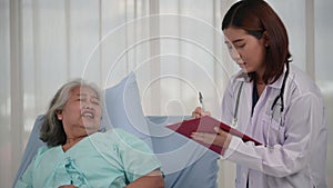 Asian nurse checking up the history of the disease elderly patient lying in bed, Elderly patient care and health lifestyle