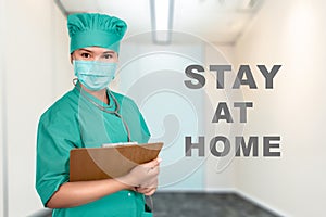 Asian nurse with flu mask and stethoscope holding a clipboard with a message for Stay at home