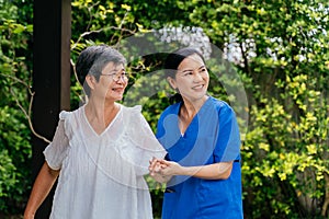 Asian nurse and patient walking in backyard